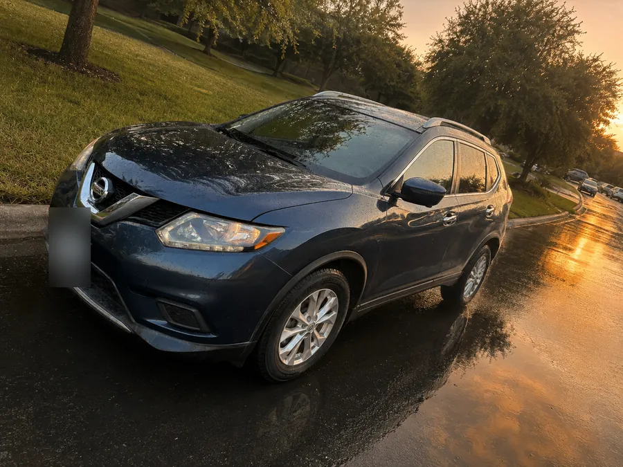 Freedom Rentals’ blue Nissan SUV on a wet street at sunset