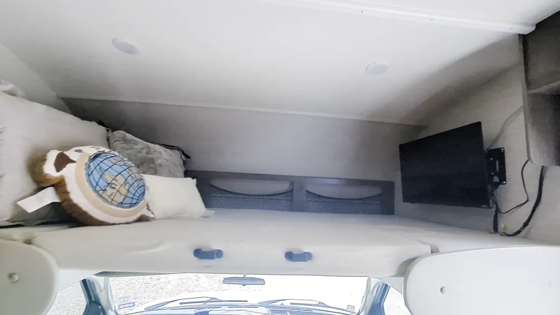 The bed over the cab, with a TV on the wall
