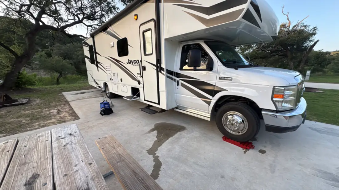Freedom Rentals’ RV on a campsite pad beside a picnic table