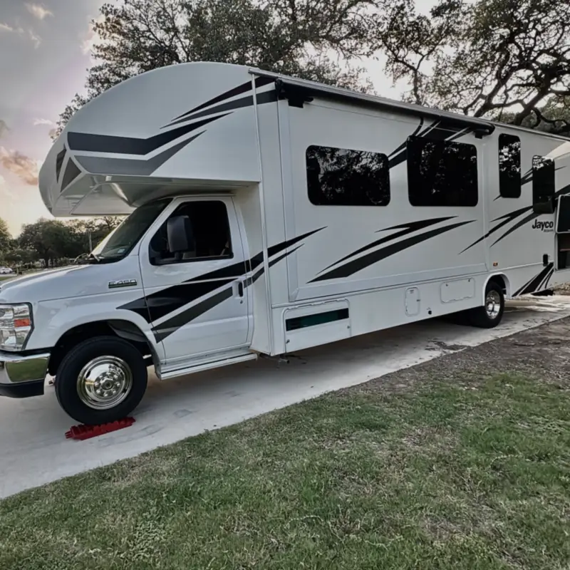 Freedom Rentals’ Class C motorhome parked at a campsite at dusk