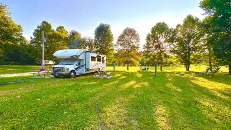 Freedom Rentals’ RV at a grassy campsite in Kansas, in evening sun