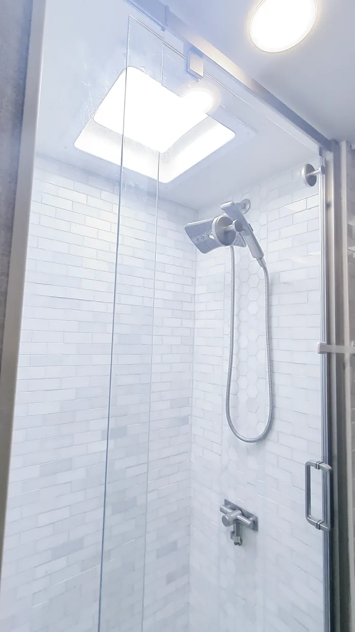 The shower, with a glass door and a skylight